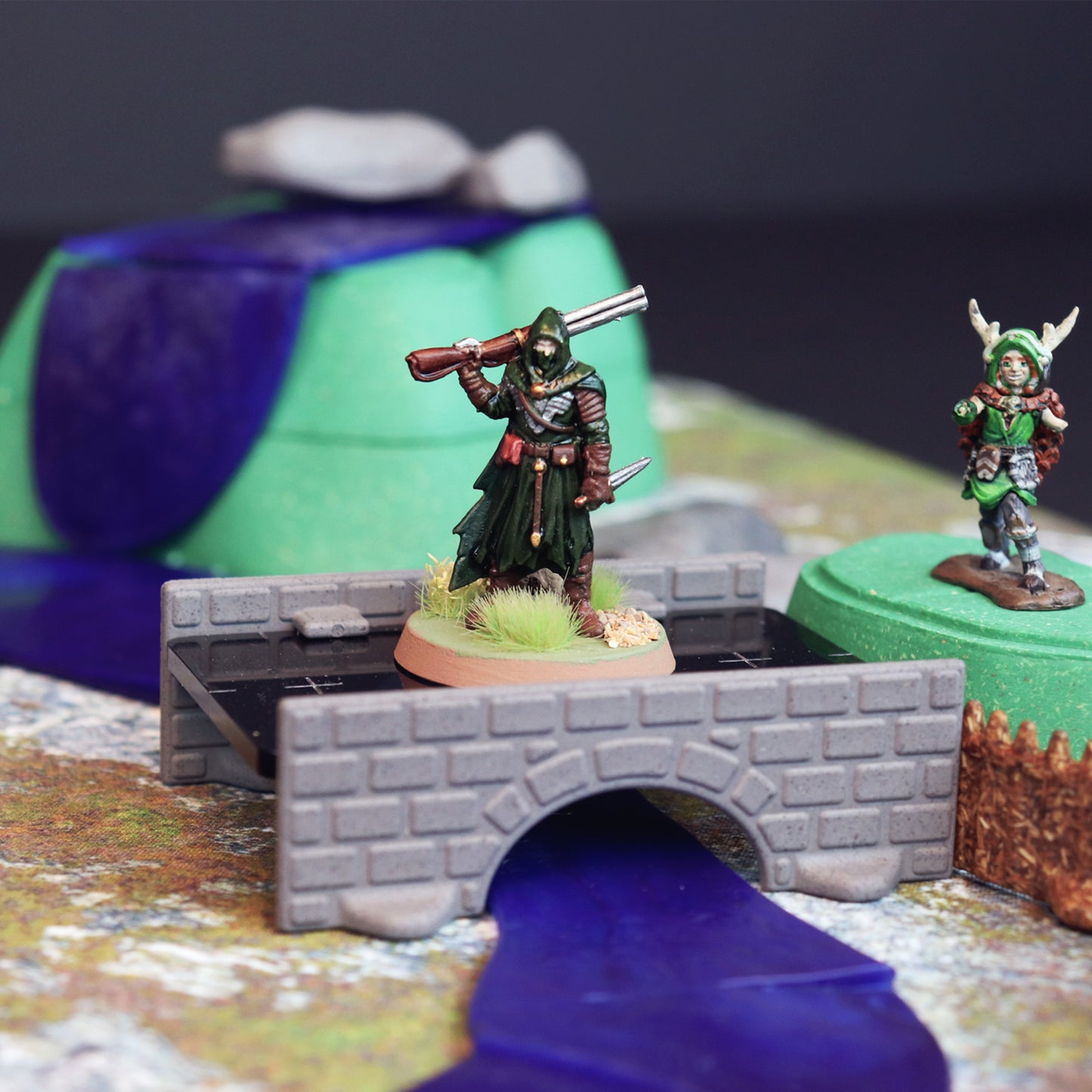 Close-up of a bandit or player entering the bandit camp by crossing a bridge over water with a waterfall in the background.