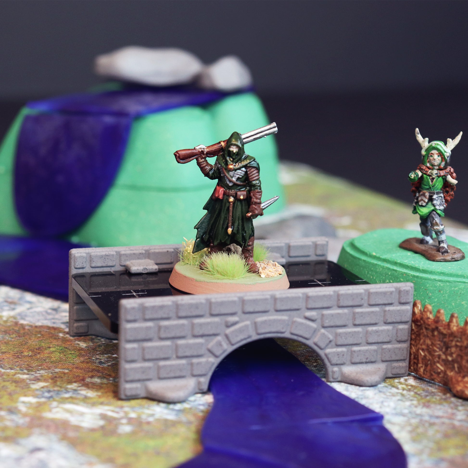 Close-up of a bandit or player entering the bandit camp by crossing a bridge over water with a waterfall in the background.