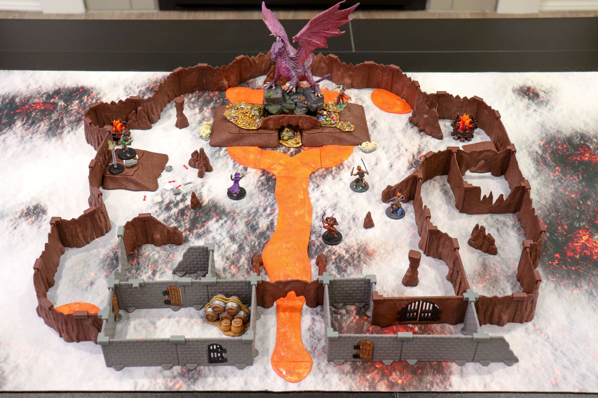 Epic scene showing a large dragon miniature dominating a combat encounter on the elevated volcanic terrain of the Dragon's Lair Adventure Set—perfect for a tabletop boss fight.