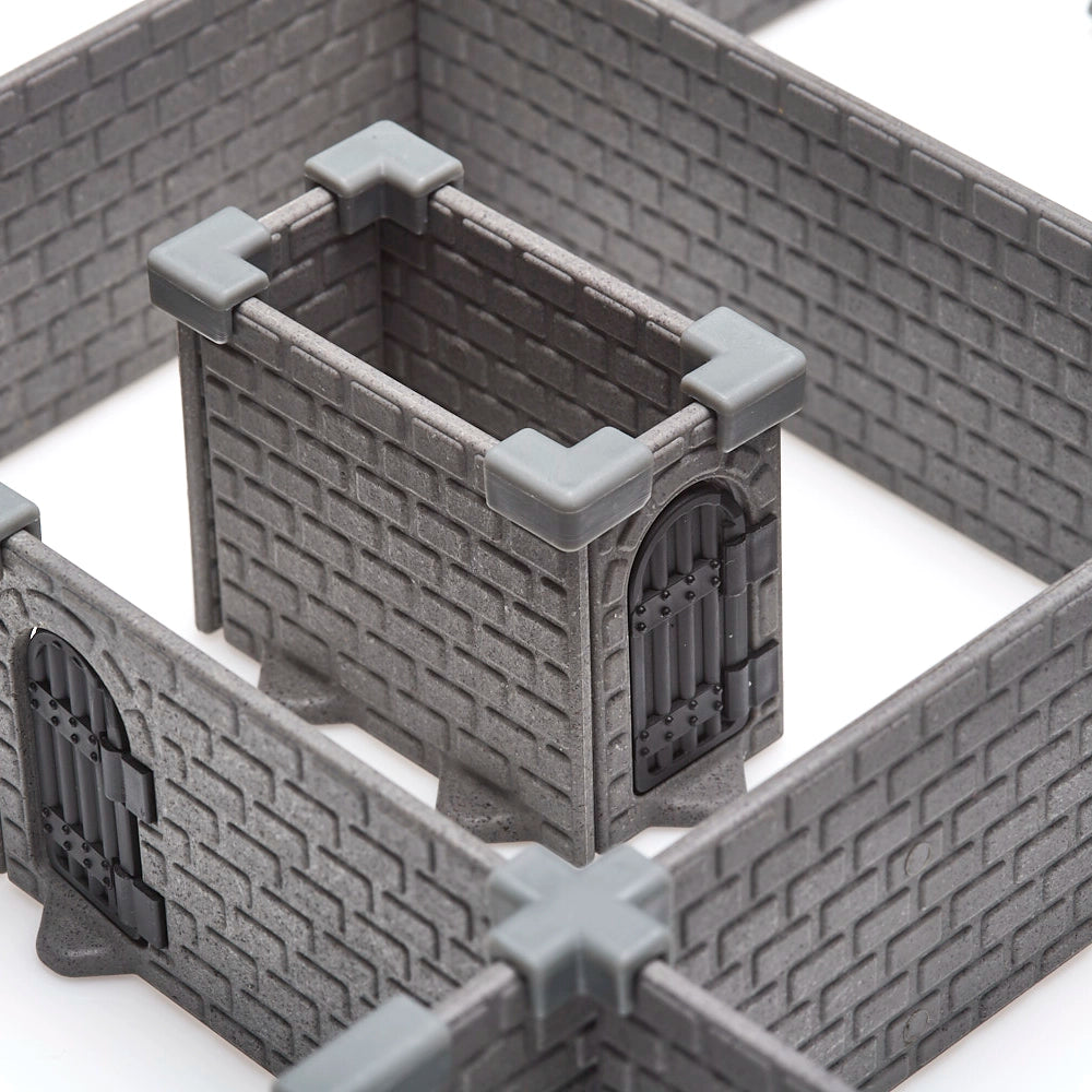 Extreme close-up of a small, contained wall section from the modular dungeon system, clearly showing the dark grey injection-molded brick texture and the grey, corner wall clips for a secure assembly.