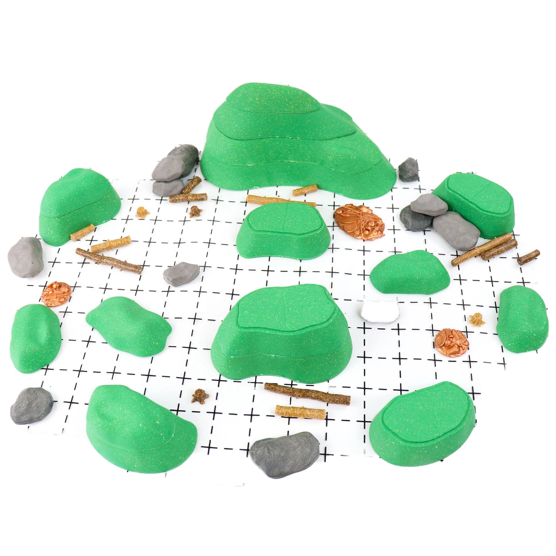 Overhead shot of the assembled pieces from the Gnoll Terrain Core Set spread out on a white grid, showcasing the different sizes of green modular hills, rocks, logs, and other outdoor scatter terrain.