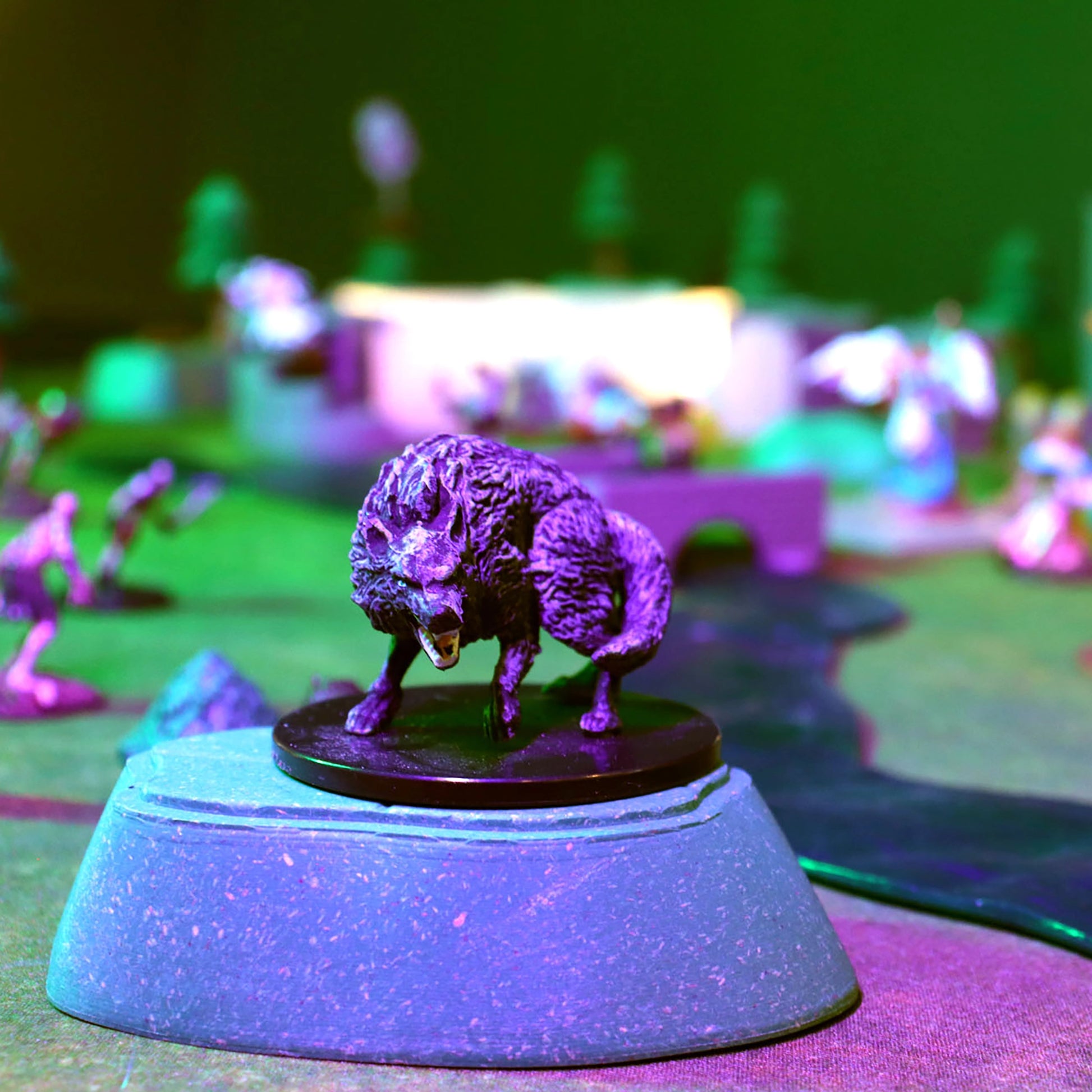 Close-up of a monstrous miniature perched on a green modular hill from the Gnoll Terrain Set, illuminated by dramatic purple and green lighting, creating a spooky outdoor D&D encounter scene.