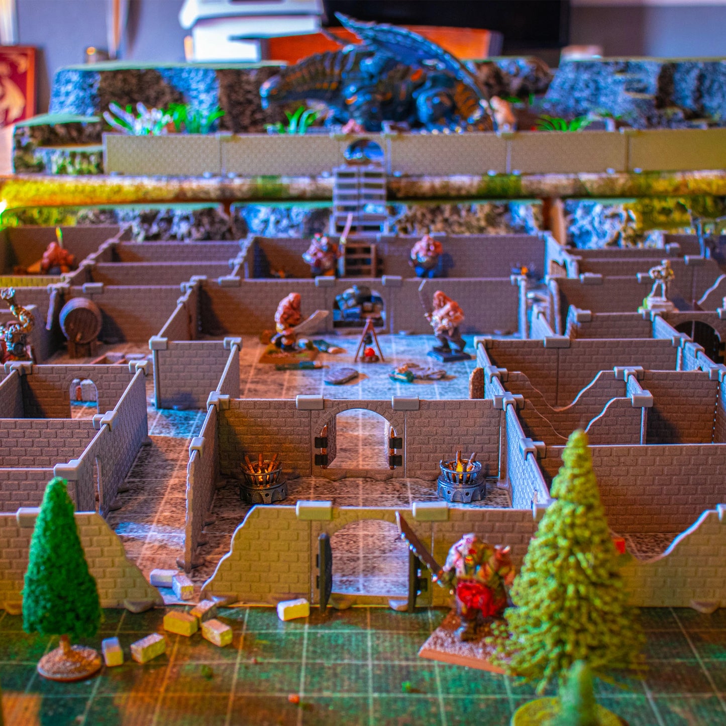 Immersive, detailed view of the Knight full dungeon set built for a tabletop RPG. The scene features multiple monsters, campfires, and barrels within the modular wall sections, creating a combat-ready atmosphere, with a large dragon in the distance.