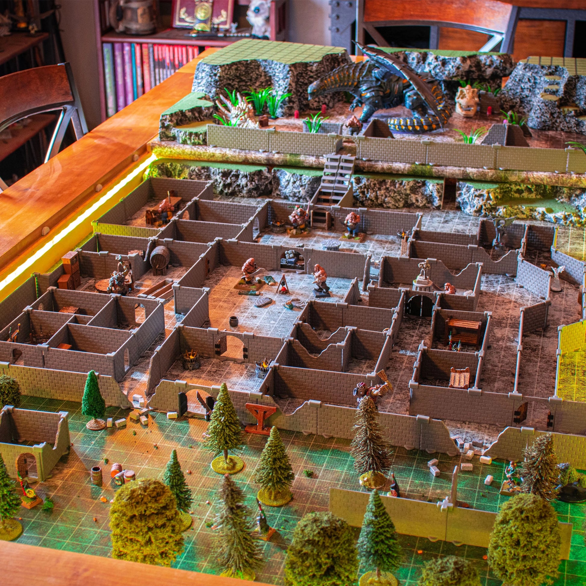 Wide overhead view of a massive Knight modular dungeon set build on a gaming table, featuring a large dragon and other miniatures, trees, and detailed rooms in an epic tabletop RPG adventure scene.