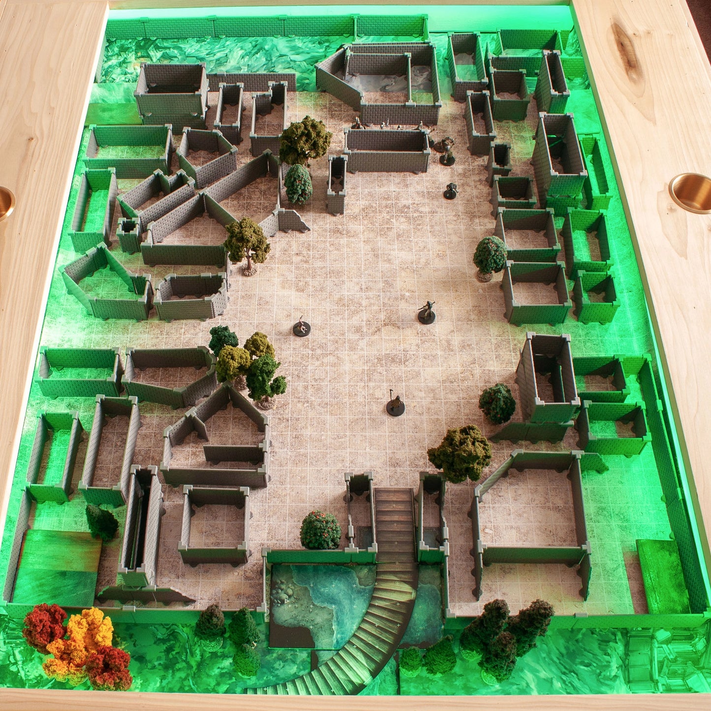 Bird's-eye view of a vast, complex Knight core set build, incorporating pieces from the Diagonal Walls Expansion along with trees and an exterior patio area, all illuminated by a vibrant green under-lighting for a fantasy RPG scene.