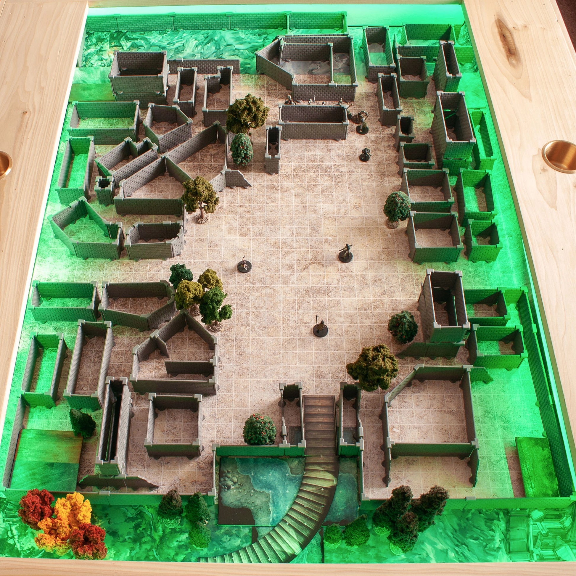 Bird's-eye view of a vast, complex Knight core set build, incorporating pieces from the Diagonal Walls Expansion along with trees and an exterior patio area, all illuminated by a vibrant green under-lighting for a fantasy RPG scene.