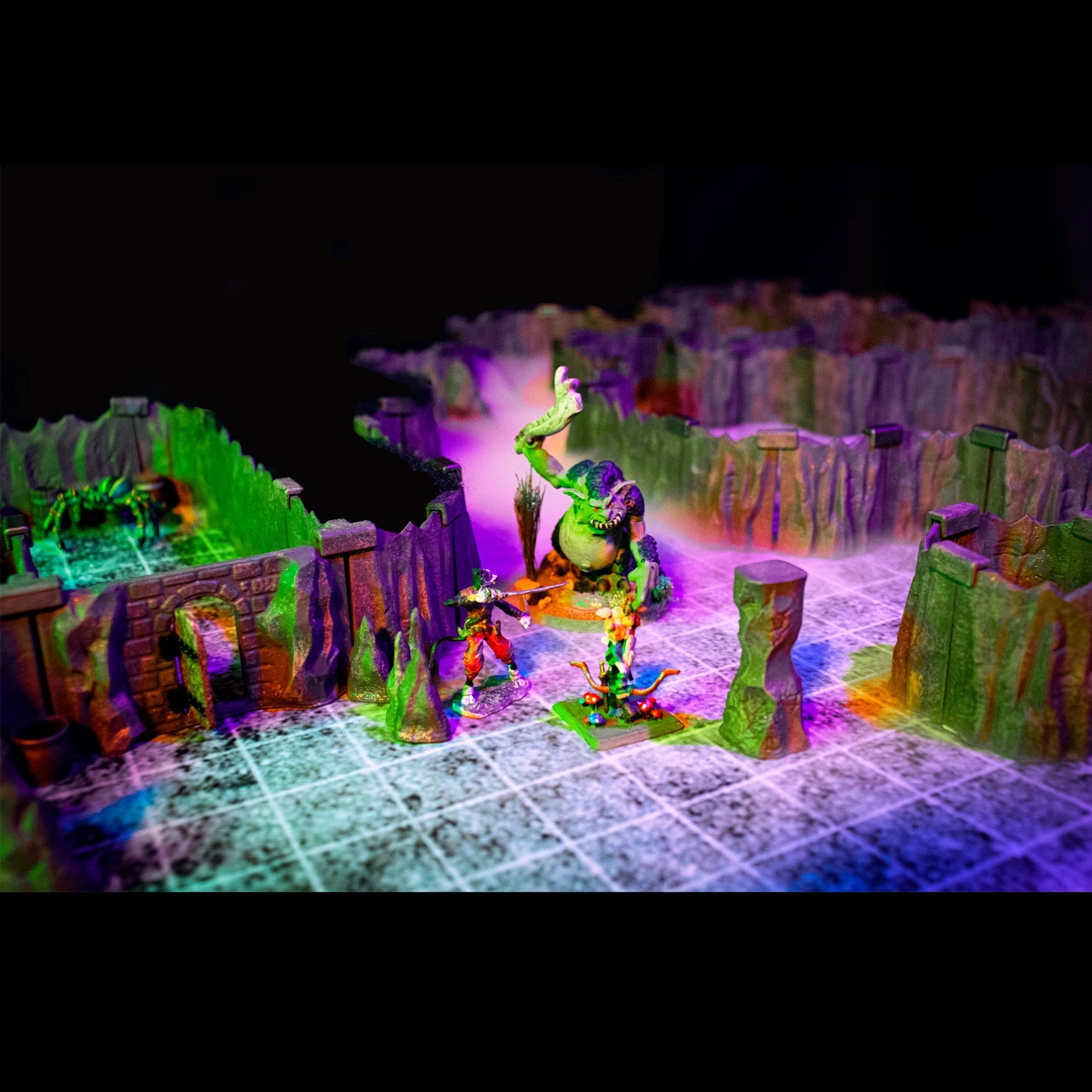 Dramatic close-up of a fantasy adventurer fighting a large green troll monster. The modular Troll Cavern terrain is illuminated by atmospheric green and purple lighting for a thematic D&D boss encounter.