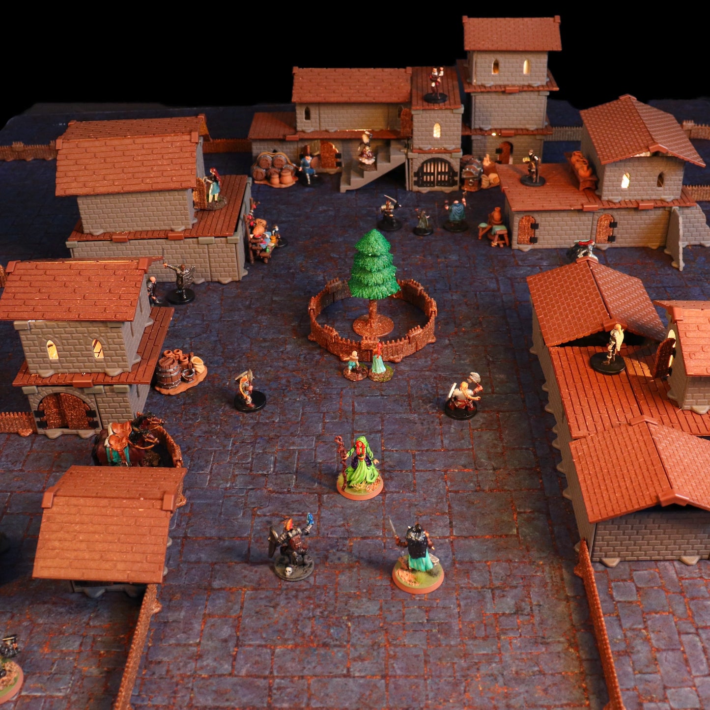 High-angle perspective showing miniatures engaged in combat on the rooftops of the village buildings, illustrating the verticality and rooftop access provided by the modular system.