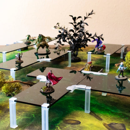 Modular TTRPG elevation terrain setup using black acrylic platforms and clear clips over a swamp or forest battle map.