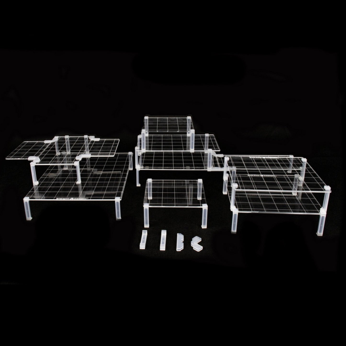 Clear acrylic platforms and clips arranged in a multi-level dungeon terrain setup on a solid black background for visibility.