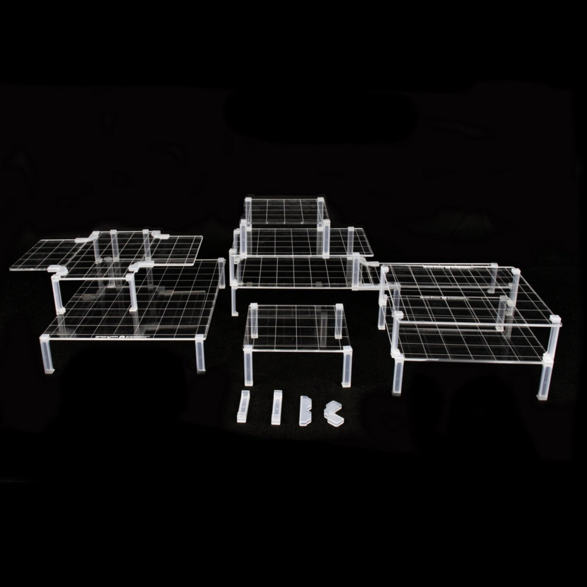 Clear acrylic platforms and clips arranged in a multi-level dungeon terrain setup on a solid black background for visibility.