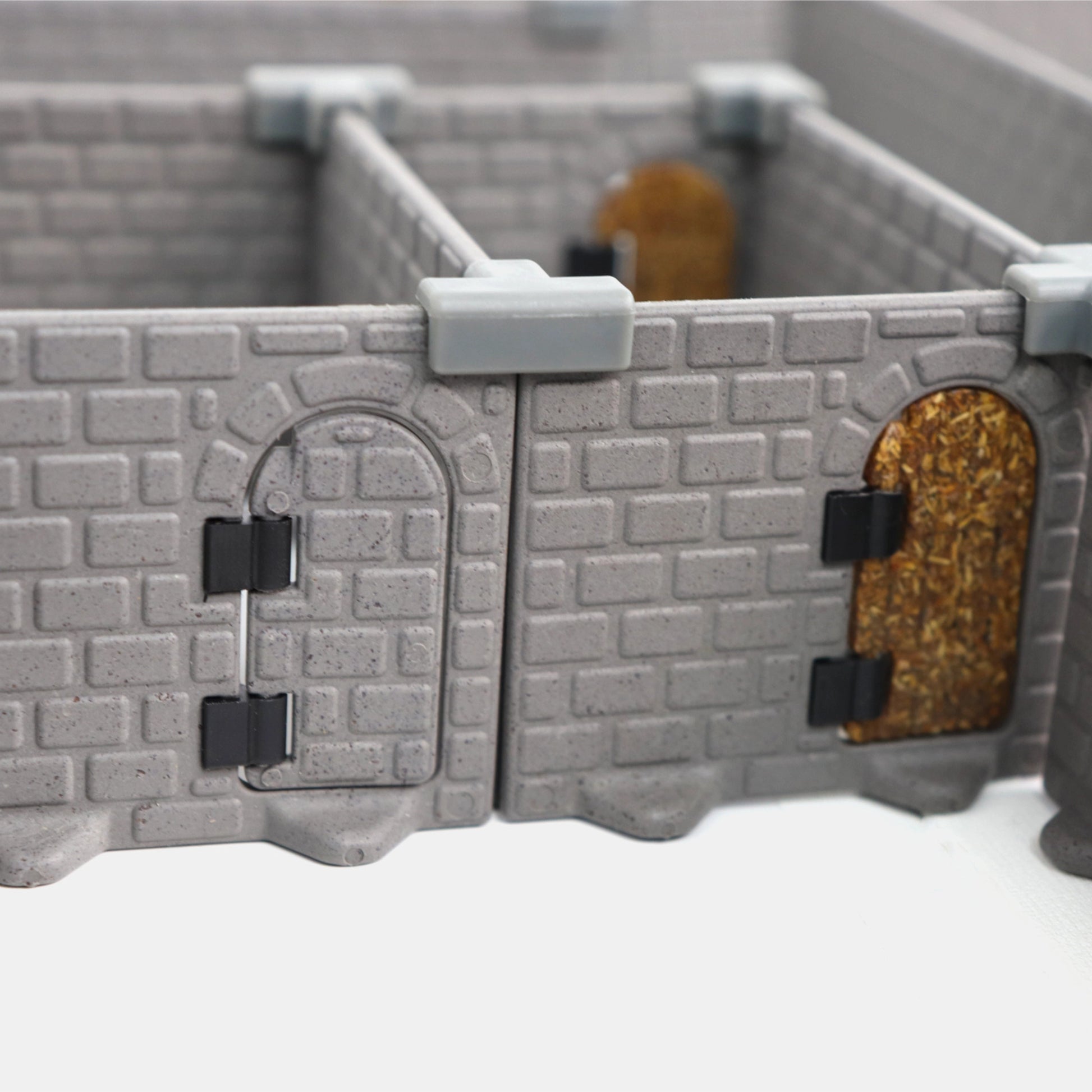 Secret Door (brick) and standard door (wood) side-by-side on modular dungeon wall tiles, showing the difference in texture and color.