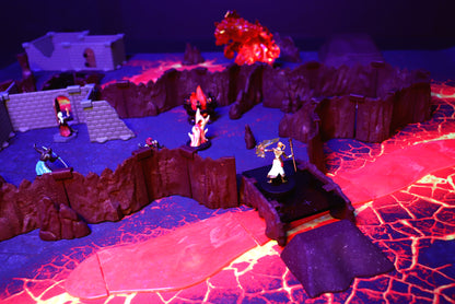 A close-up TTRPG scene featuring a warrior miniature standing on a Rock Bridge piece, crossing a glowing Lava River, surrounded by Cavern Walls.