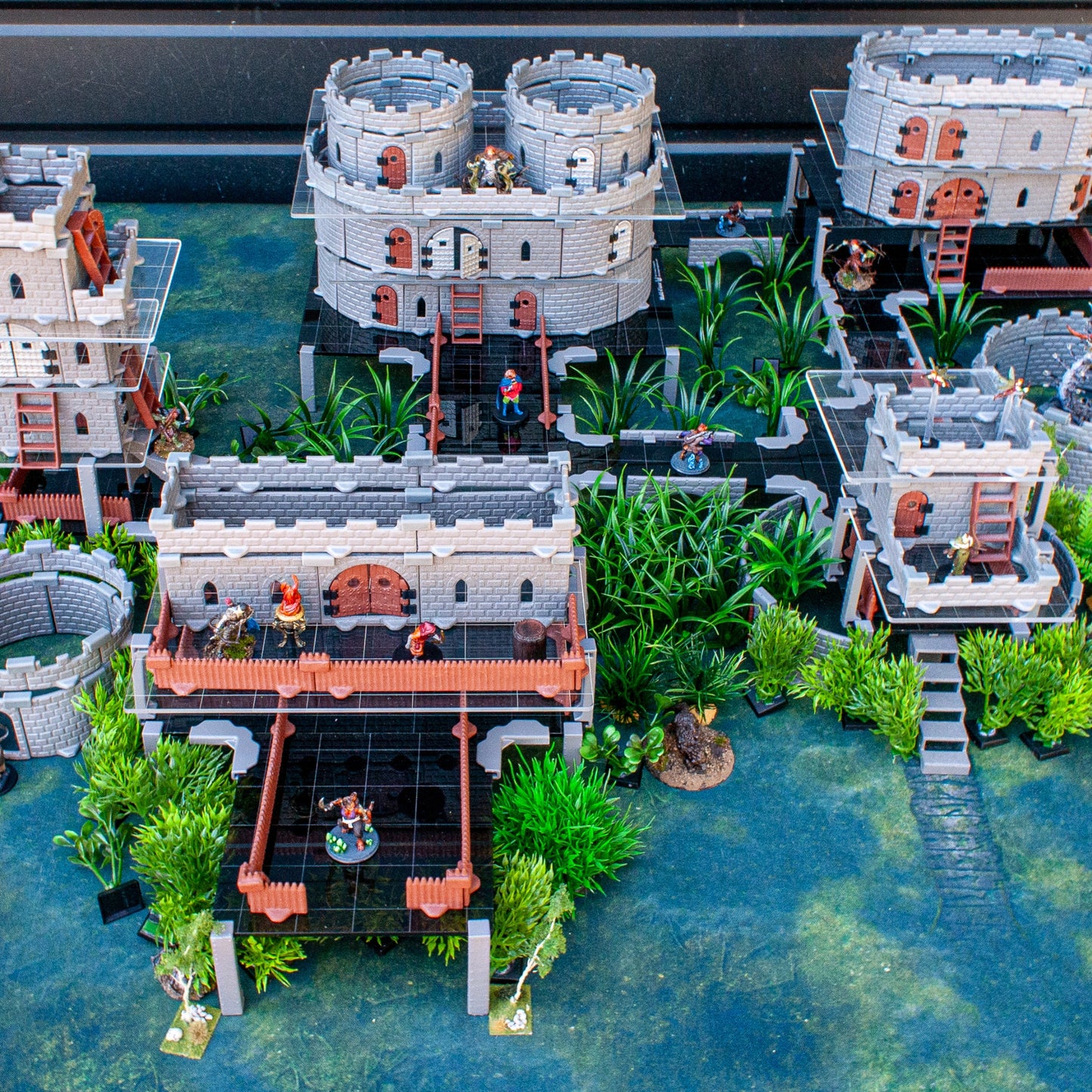 Close-up of a complex DND castle structure supported by the acrylic platform clips, integrated with scatter terrain and miniatures.