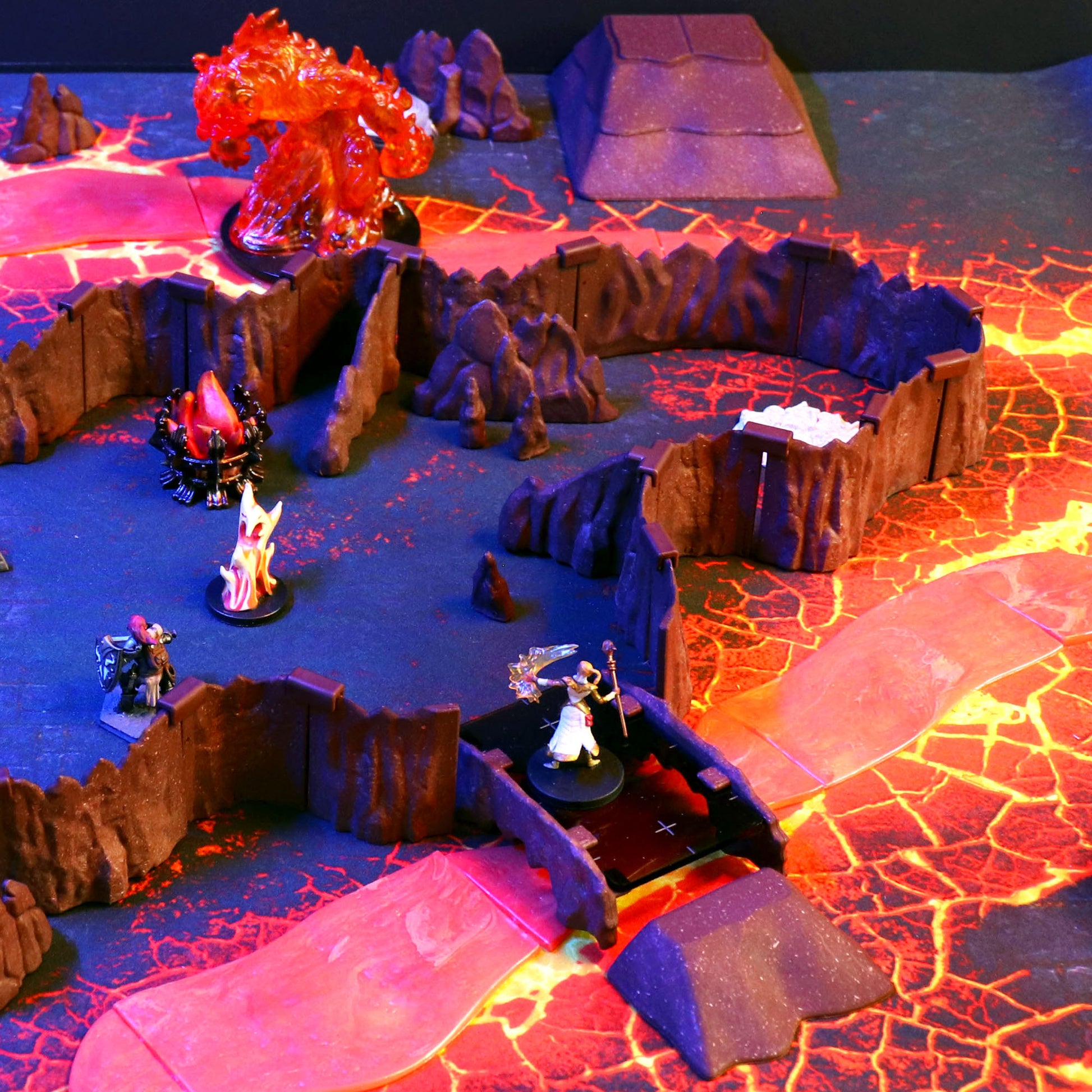 Dramatic TTRPG setup showing a character miniature crossing a Rock Bridge over a vibrant lava chasm, surrounded by cavern walls and a fire elemental monster.