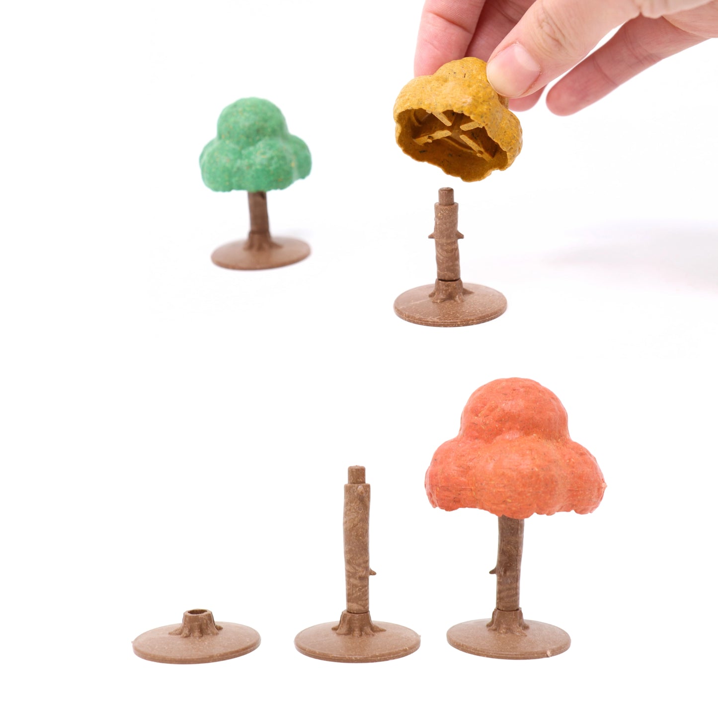 Demonstration of the modular assembly for the Autumn-Hued Forest Kit, showing how the canopy piece attaches to the trunk and stand.