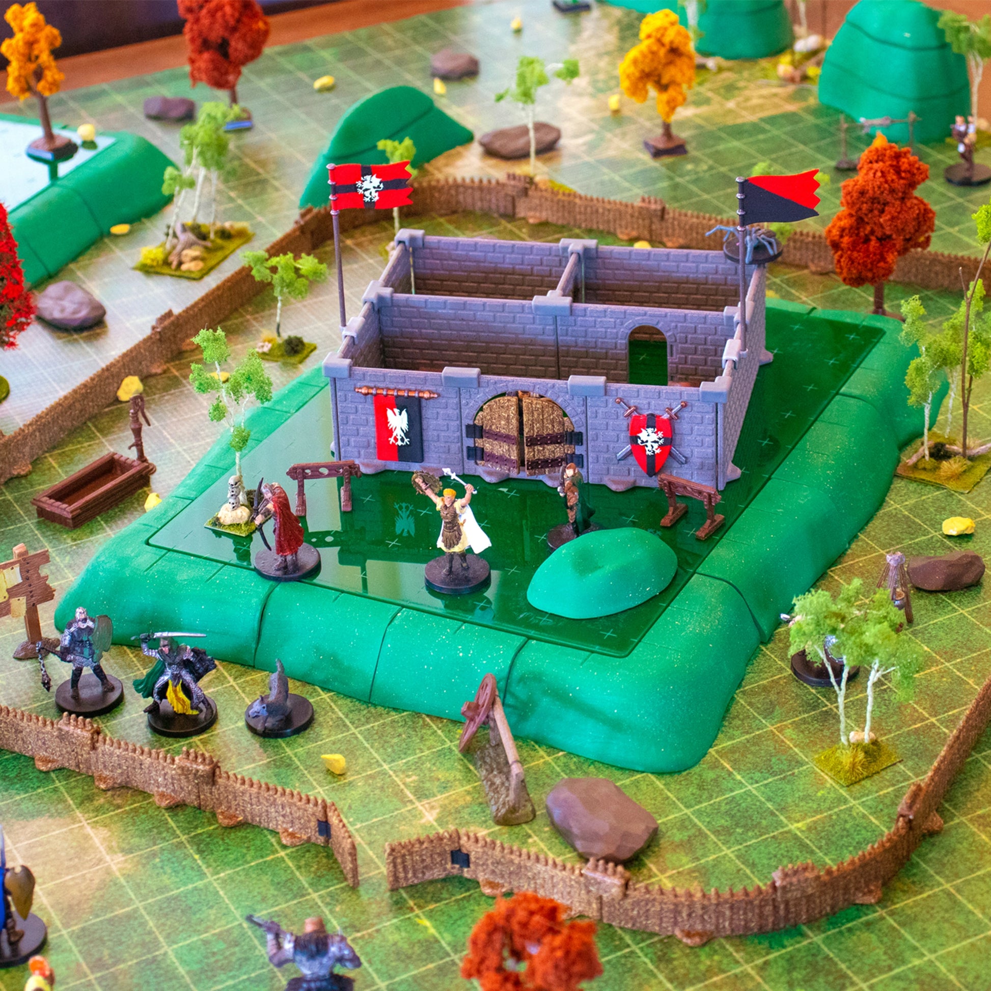 Close-up of the scatter pieces included in the set, featuring modular ruins, rock piles, logs, and a palisade-style structure, adding detail to the outdoor RPG terrain.