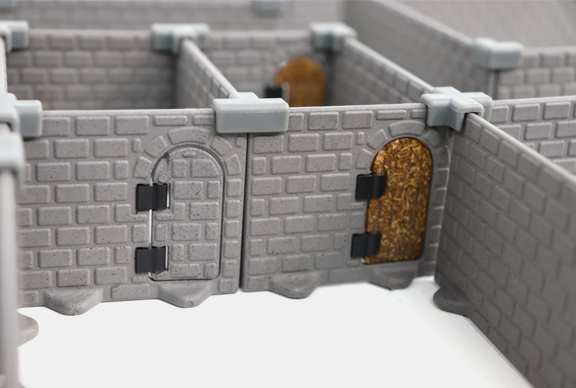 Extreme close-up of the HQ Set modular walls showing the detailed brick texture and hinged dungeon doors (closed and open).