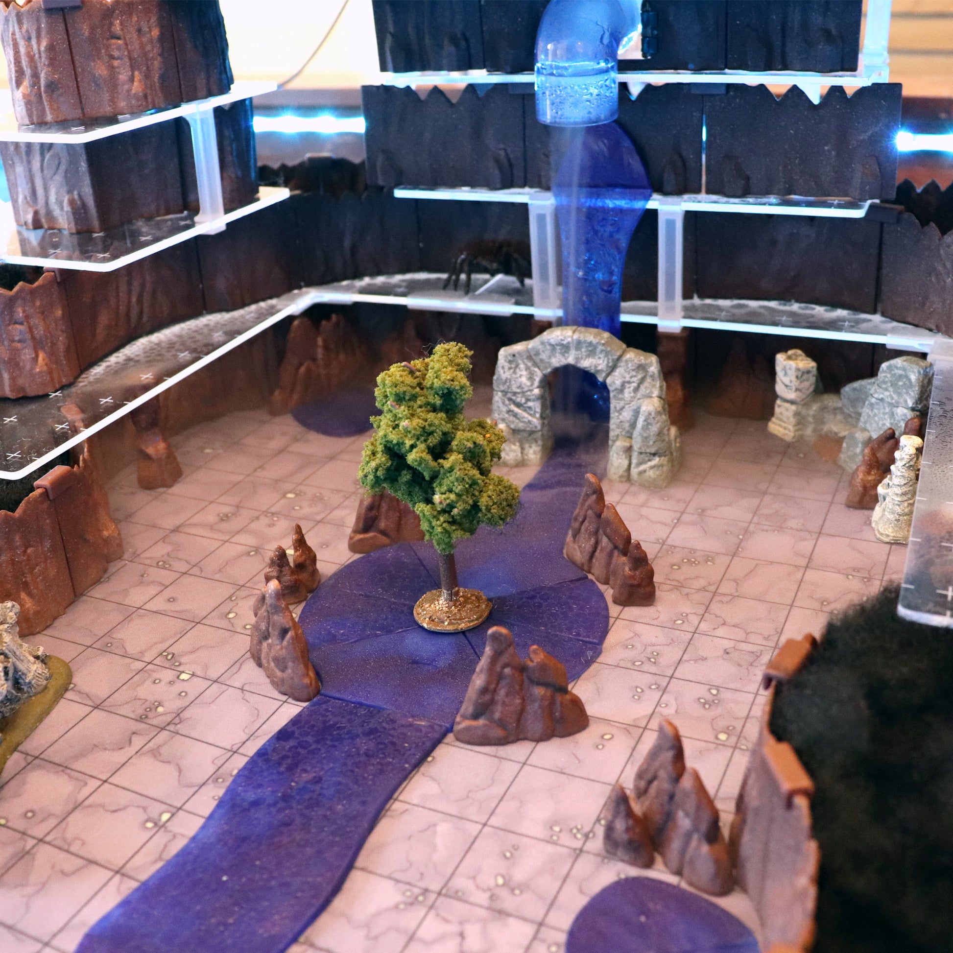 Complex multi-level cave terrain with a waterfall flowing into a waterway section, surrounded by brown modular walls.