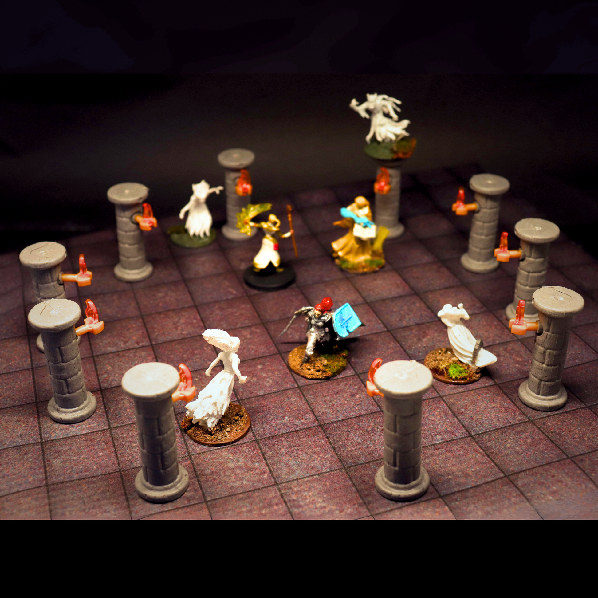 A Dungeons and Dragons battle scene using multiple stone pillars and torches terrain pieces and various hero and ghost miniatures.