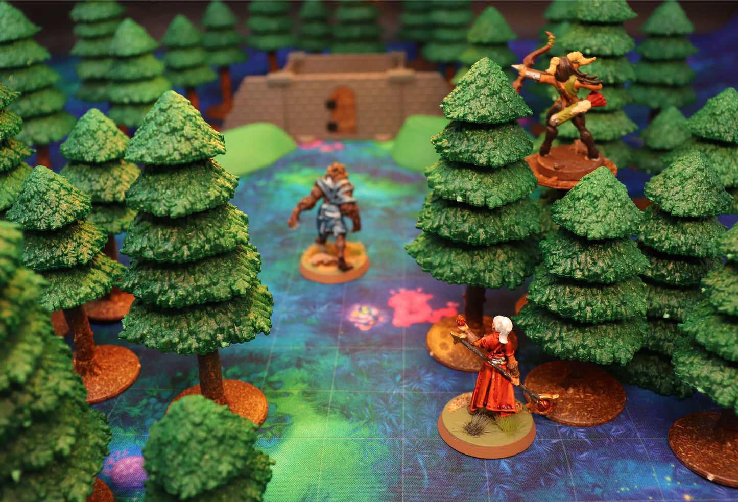 Hero miniatures ambushing a large werewolf-like monster on a raised rock platform surrounded by the Dark Pine Forest trees.