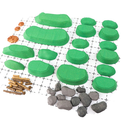 Clean, isolated view of all the unassembled pieces of the Gnoll Terrain Core Set on a white grid, including green modular hills, gray rocks, brown logs, and stumps. Shows all outdoor scatter terrain elements.
