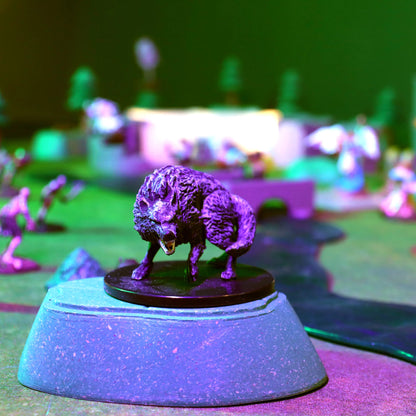Close-up of a monstrous miniature perched on a green modular hill from the Gnoll Terrain Set, illuminated by dramatic purple and green lighting, creating a spooky outdoor D&D encounter scene.