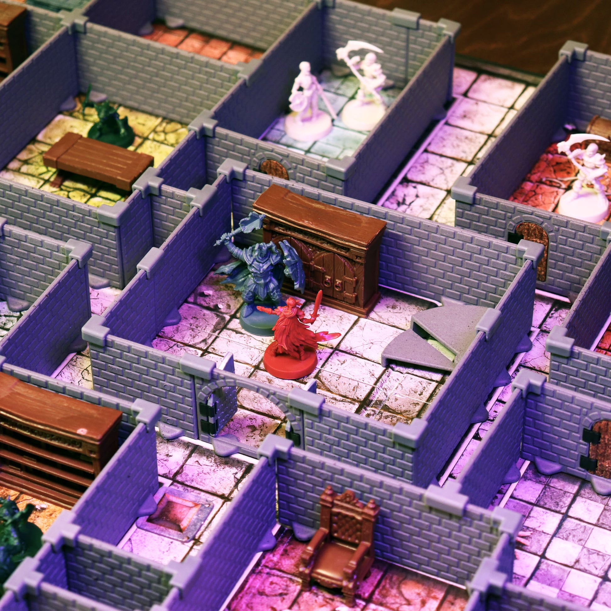 Close-up of HeroQuest miniatures battling in a dungeon room built with the HQ Set walls, featuring furniture and dramatic lighting effects.