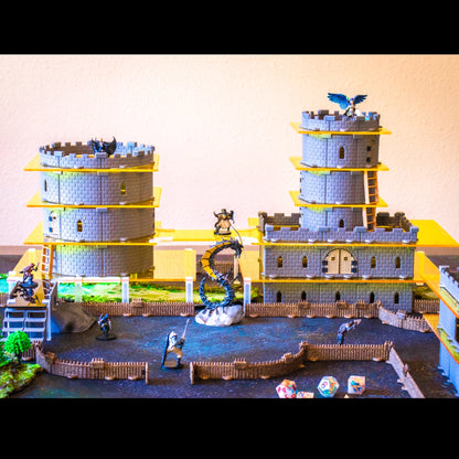 Castle set with towers, dragons, and figures on a cobblestone battle mat using yellow acrylic.