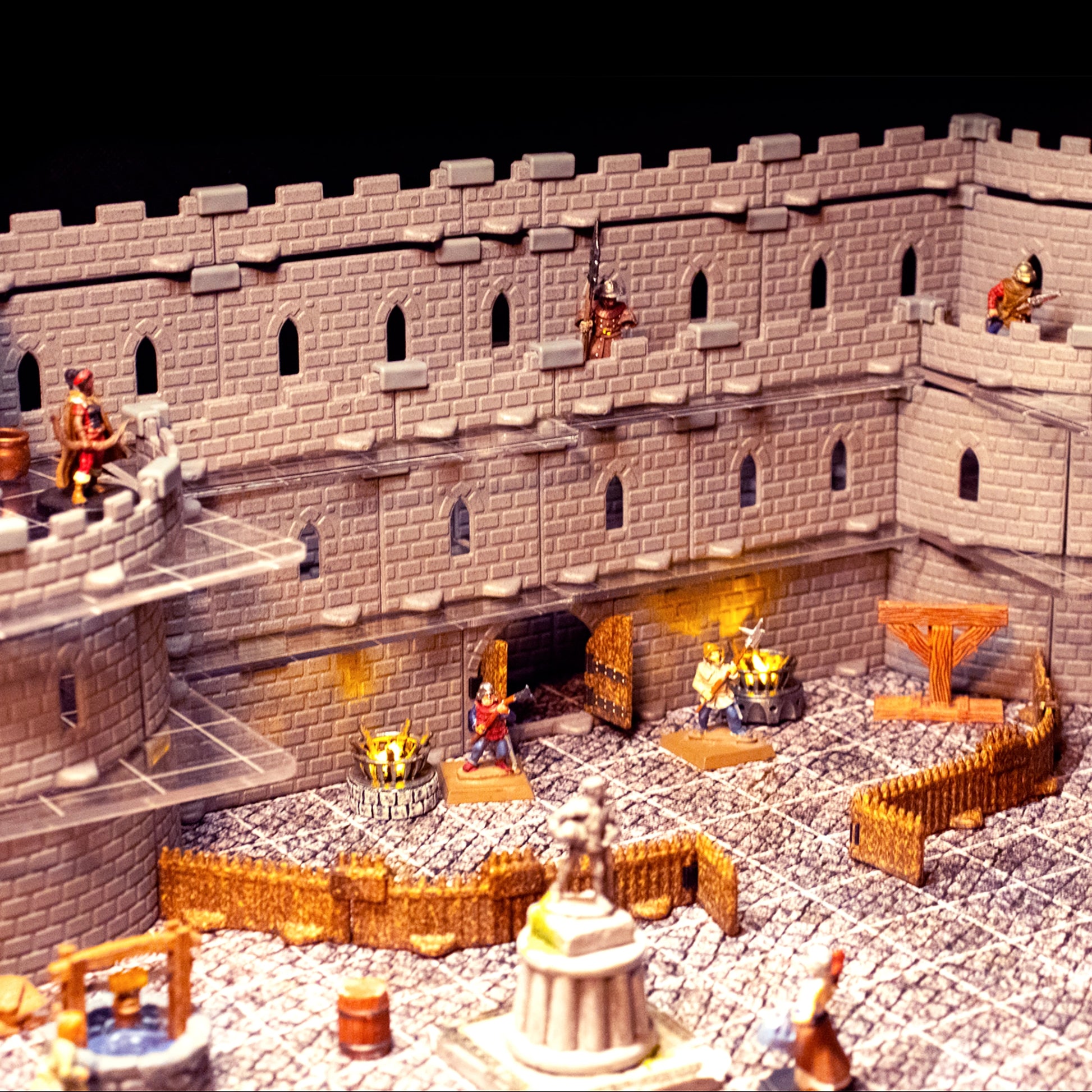 Detailed scene showcasing the Regent Castle Set configured with a large central courtyard and an imposing gatehouse section, featuring windowed walls and miniatures for a tabletop RPG entry point.