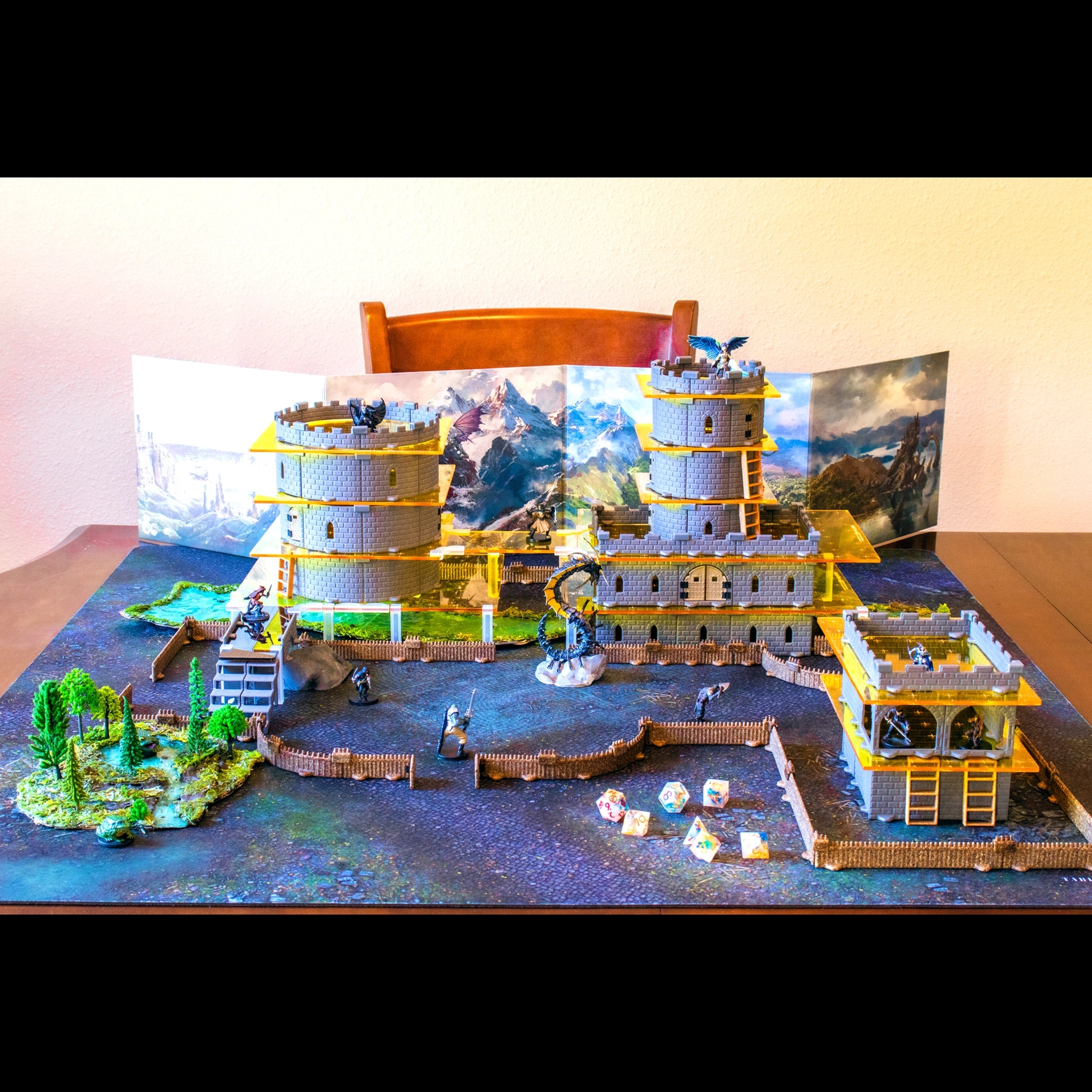 Wide, detailed view of the massive, fully assembled Regent Castle Core Set modular terrain against an outdoor backdrop. The build includes high vertical walls, a courtyard, and multiple towers, showcasing its scale as the largest castle set.