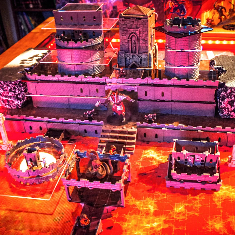 Wide-angle view of a dramatic multi-story Regent Castle build on a lava-themed mat, highlighting the complex vertical architecture, multiple acrylic platforms, and a large number of fantasy miniatures.