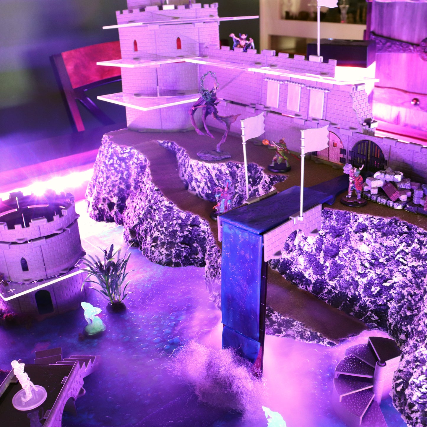 A dramatic scene of a large castle perched on a cliff with a waterfall made using the Waterway Kit pouring into a half-sunken city below.