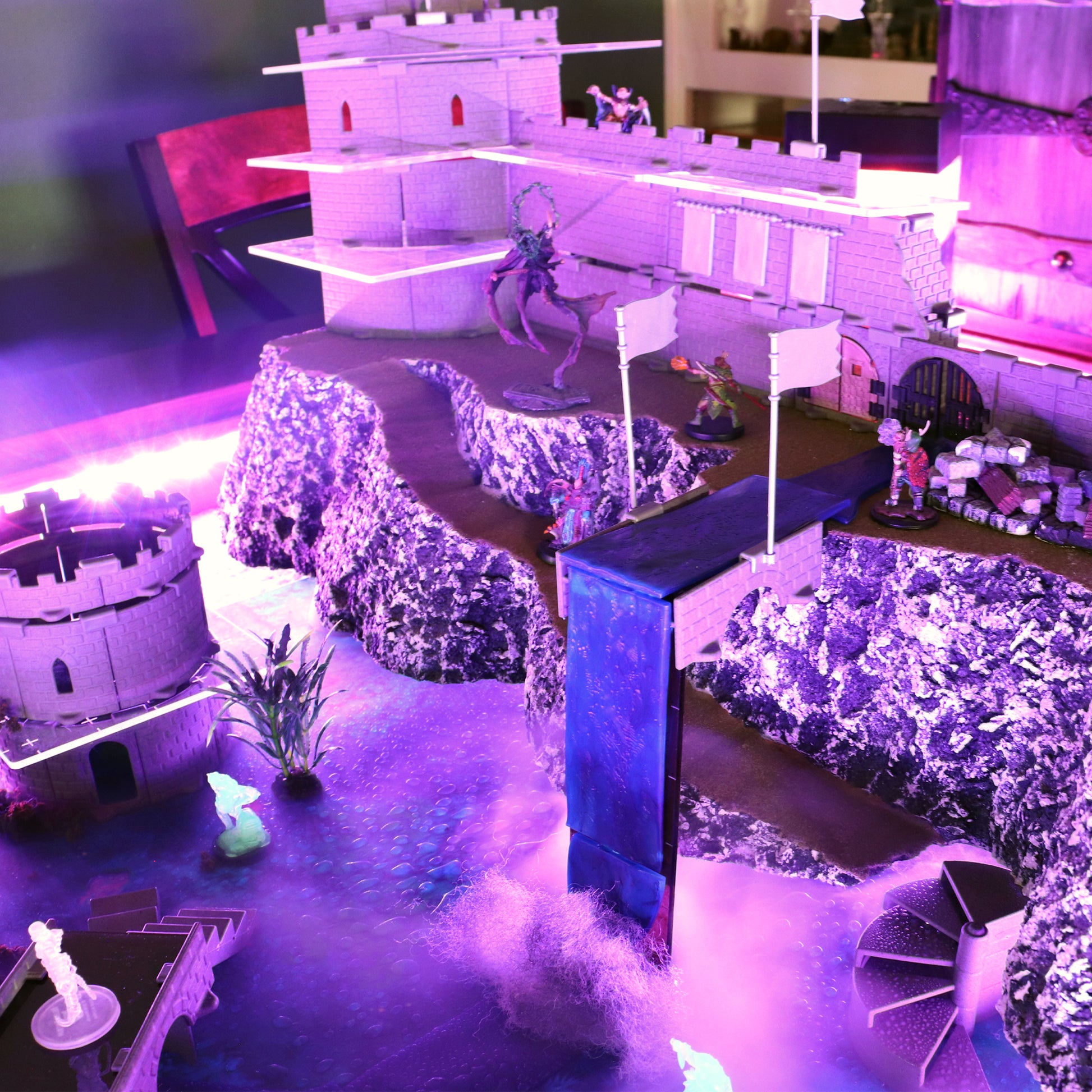 A dramatic scene of a large castle perched on a cliff with a waterfall made using the Waterway Kit pouring into a half-sunken city below.