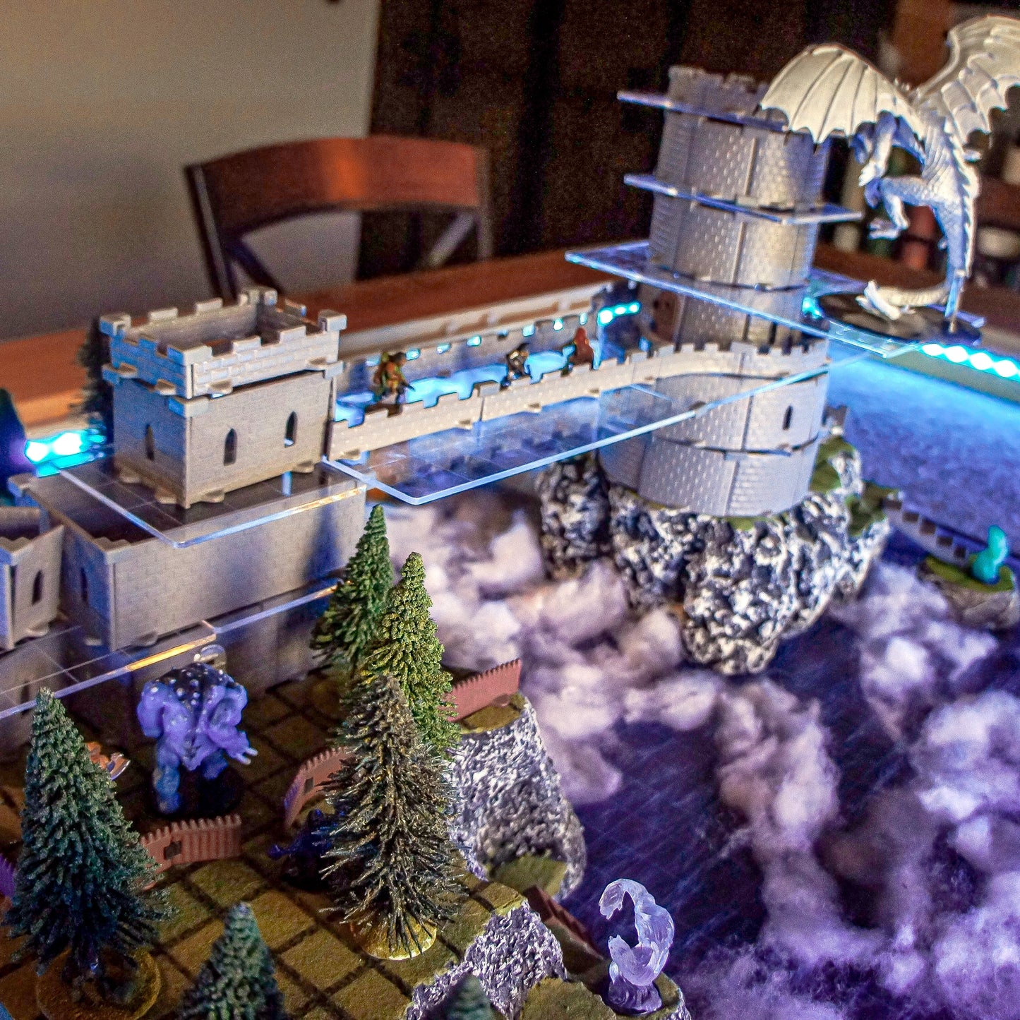 Scene showing the Wizard's Tower Set configured with a long bridge or walkway piece connecting to the main tower structure, with various miniatures moving between sections for a D&D encounter.