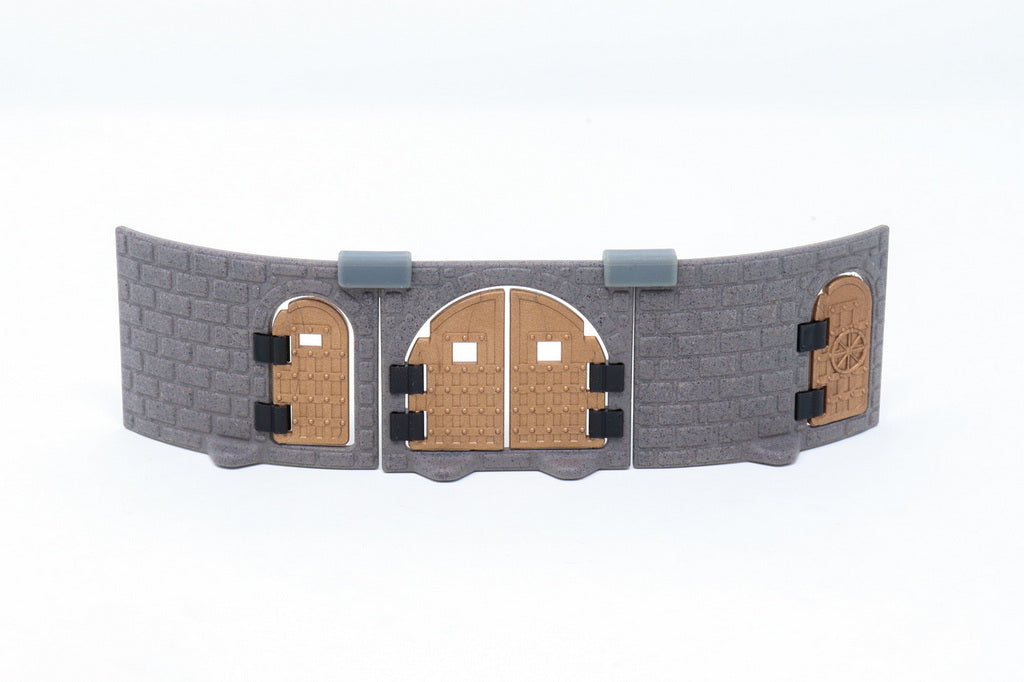 Gray modular castle wall section featuring three installed copper/brown metallic doors of different shapes and designs.