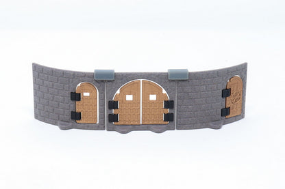 Gray modular castle wall section featuring three installed copper/brown metallic doors of different shapes and designs.