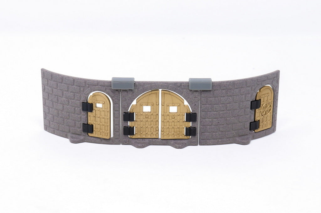 Gray modular castle wall section featuring three installed gold/bronze metallic doors of different shapes and designs.